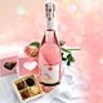 Geschenk mit Prosecco und Pralinen in rosa Herzbox